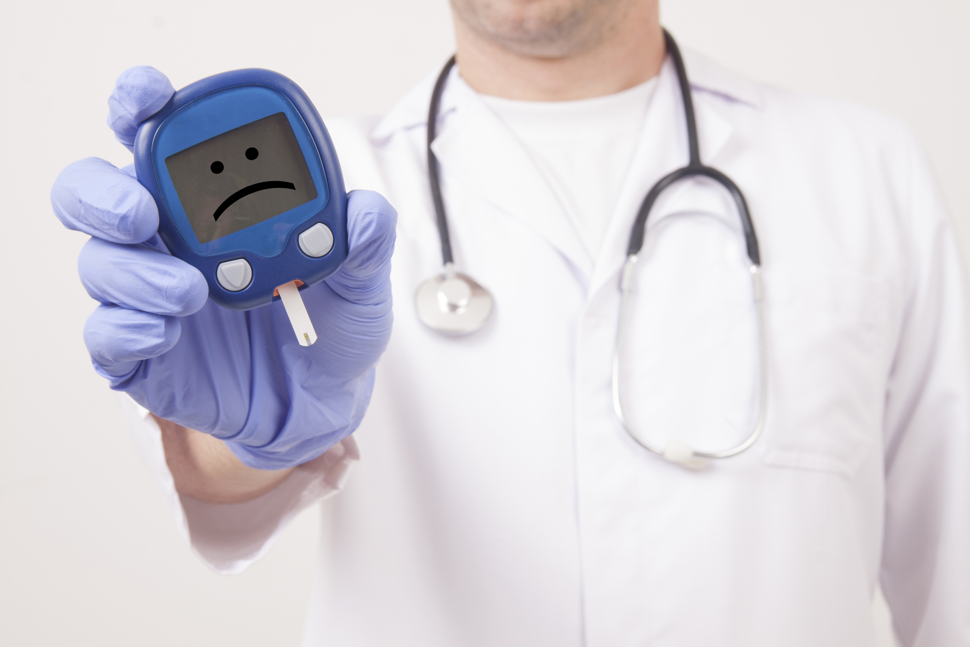 Doctor holding blood sugar meter displaying a sad face